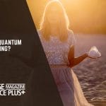 A woman standing on a beach at sunset, holding a crystal in her hand, symbolizing quantum healing practices.