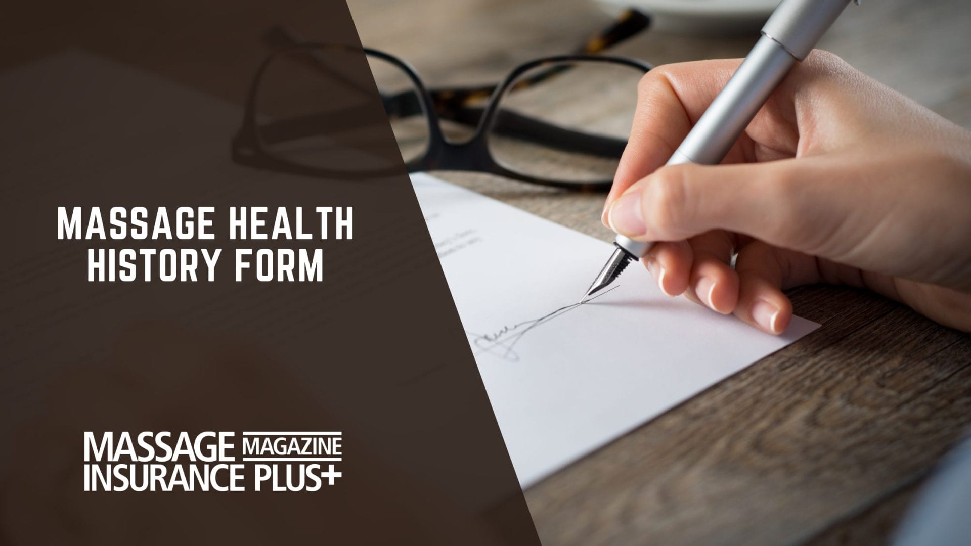 Close-up of a person signing a health history form with a silver pen, glasses resting on the wooden table in the background.